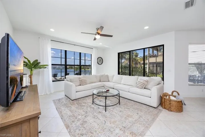 Living room with light tile patterned floors and ceiling fan