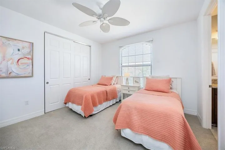 Carpeted bedroom featuring a closet and ceiling fan