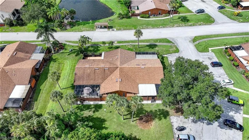 Property featuring a brown shingle roof, a screened patio, and mature landscaping