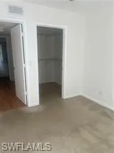 Unfurnished bedroom with a spacious closet and baseboards