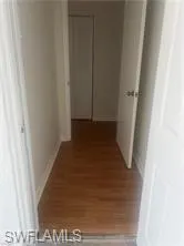 Corridor with wood finished floors and baseboards