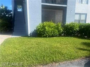 Property entrance featuring a yard and stucco siding