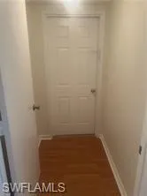 Hallway with dark wood-style floors and baseboards