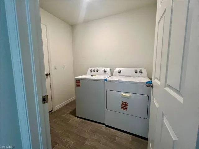 Laundry area featuring washing machine and dryer and baseboards