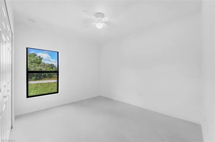 Spare room with a ceiling fan and baseboards