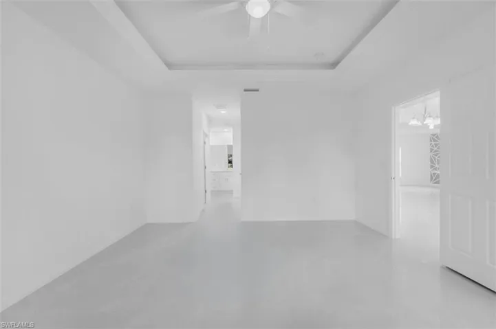 Spare room featuring a raised ceiling and ceiling fan