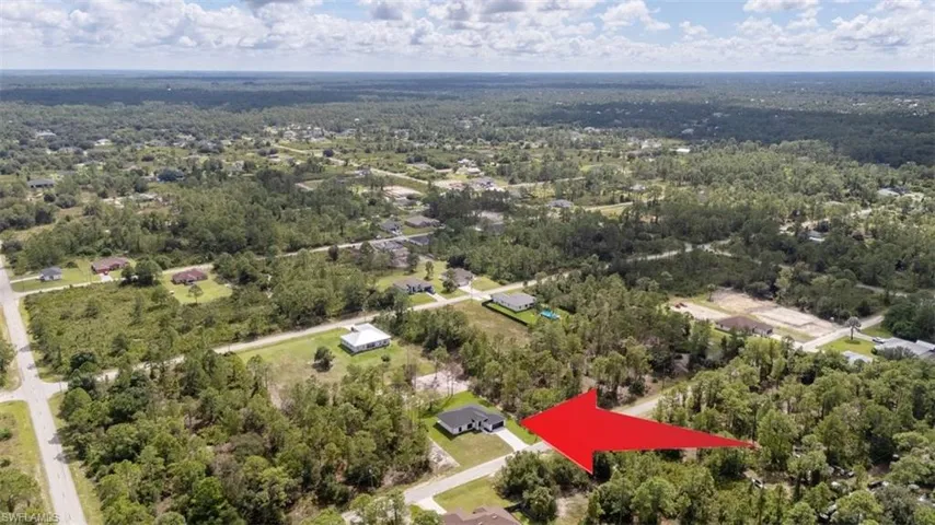 Aerial view of property and surrounding area with a heavily wooded area