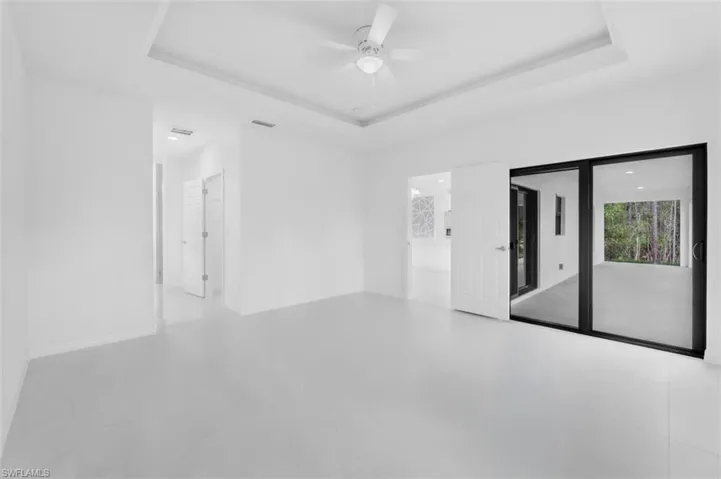 Spare room featuring a raised ceiling and a ceiling fan