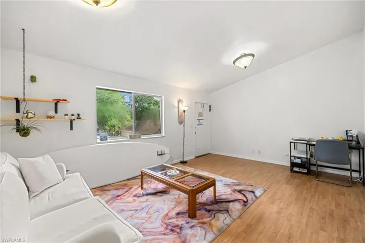Recessed window offering natural light, wood-finish flooring, and built-in wall shelving