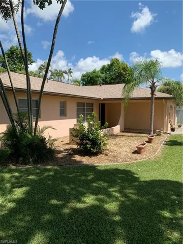 Back of property with stucco siding and a lawn