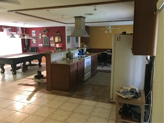 Kitchen featuring visible vents, ventilation hood, decorative light fixtures, white range with electric stovetop, and a ceiling fan