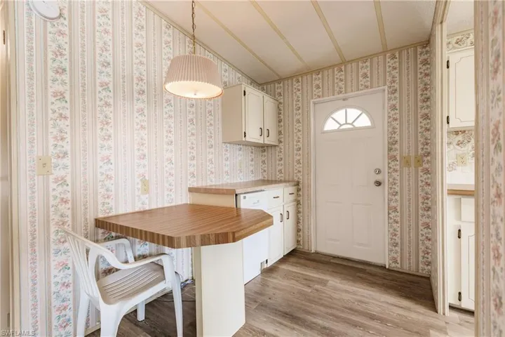 Kitchen with decorative light fixtures, light wood-type flooring, and kitchen peninsula
