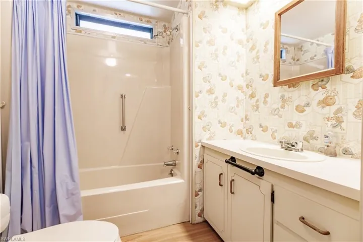Full bathroom featuring shower / tub combo, hardwood / wood-style floors, toilet, and vanity
