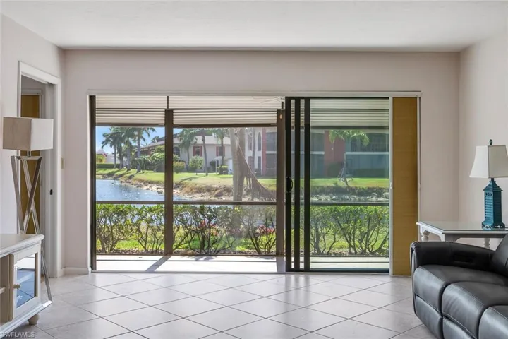 Living room with light tile flooring and a water view