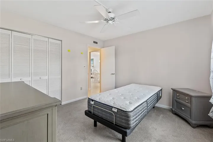 Bedroom featuring light colored carpet, a closet, and ceiling fan
