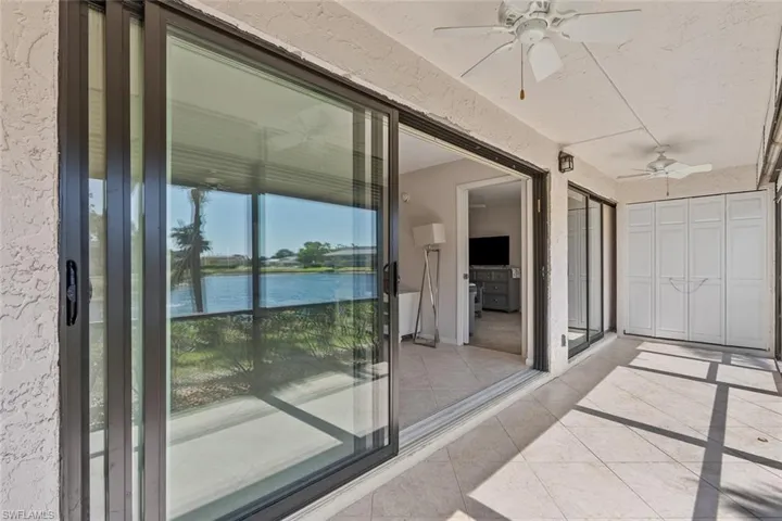 Sunroom / solarium with ceiling fan and a water view