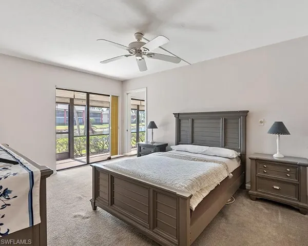 Bedroom featuring ceiling fan, light carpet, and access to outside