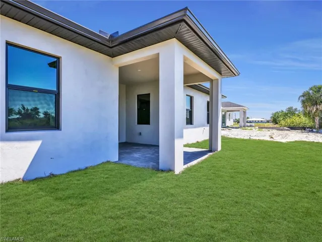 Back of house showing covered patio - the grass color has been virtually enhanced