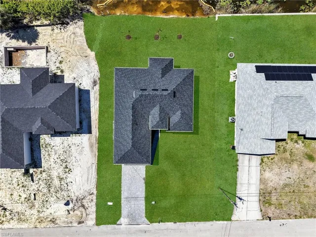 Newly sodded lawn surrounding a dark shingle roofline  the color of the grass has been virtually enhanced