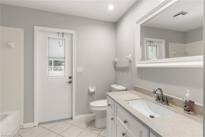 Full bathroom featuring tile patterned flooring, vanity, toilet, and tiled shower / bath