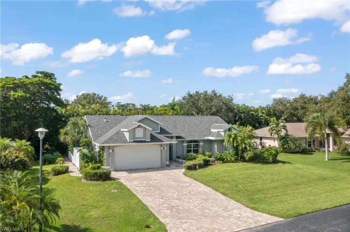Single story home featuring a garage and a front yard