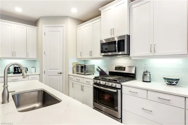 Glass tiled backsplash door leads to pantry