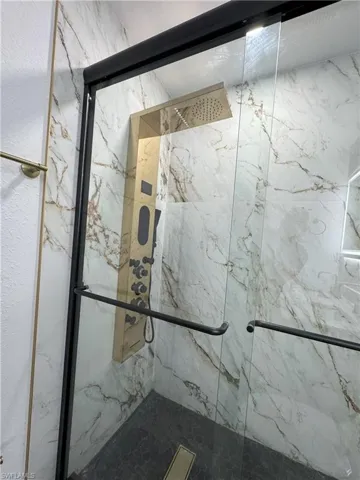 Room details with a shower with shower door