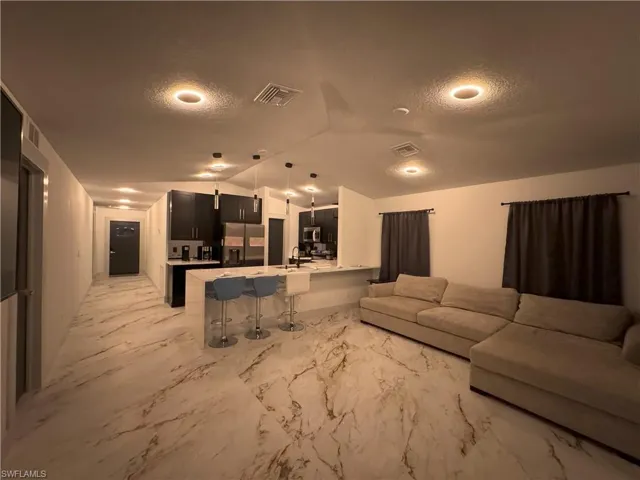 Living room featuring sink and lofted ceiling