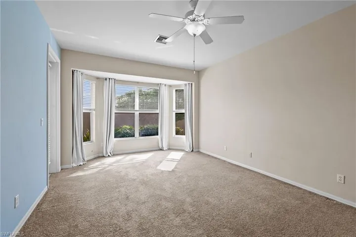 Carpeted Primary Bedroom featuring baseboards and a ceiling fan