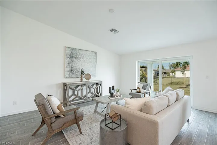 Living area with wood finish floors and vaulted ceiling