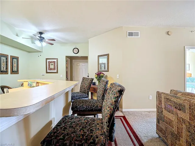 Carpeted dining area featuring ceiling fan and a textured ceiling