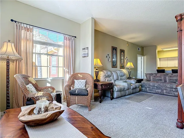 Living room featuring a wealth of natural light, carpet floors, and a textured ceiling