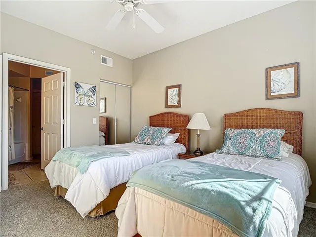 Carpeted bedroom featuring a closet and ceiling fan