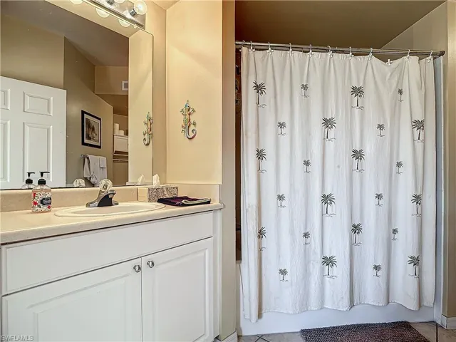 Bathroom with vanity and shower / bath combo with shower curtain