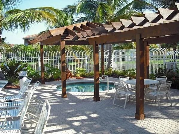 View of hot tub with a pergola and a patio