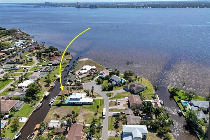 Aerial view of property and surrounding area with nearby suburban area and a nearby body of water