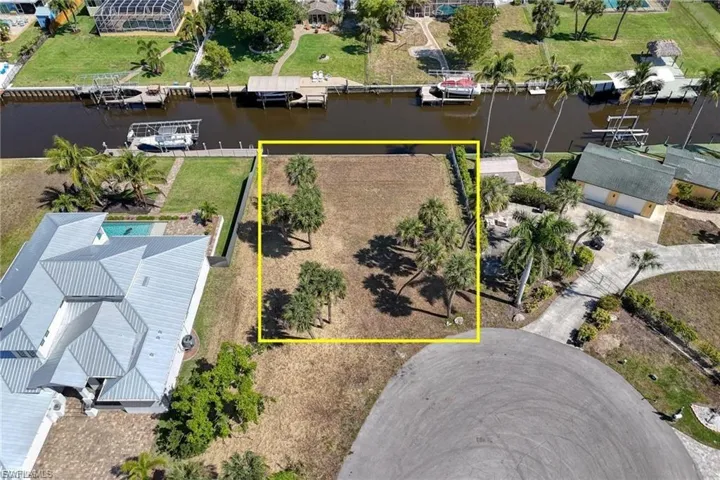 Aerial perspective of suburban area featuring a large body of water and property boundaries highlighted