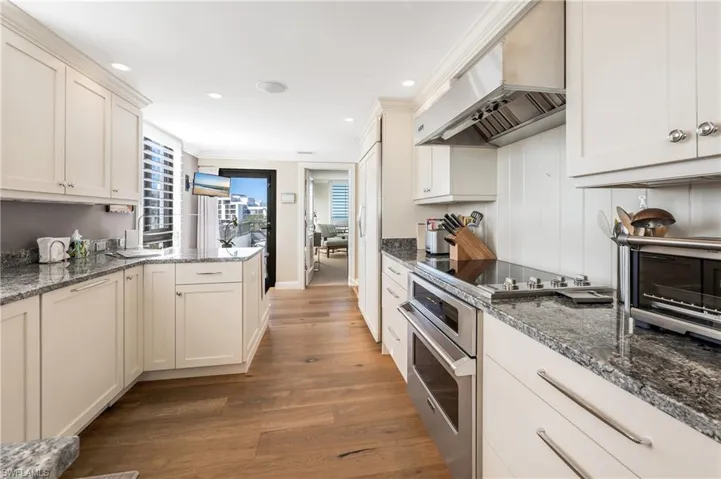 Light, custom cabinets enhance this kitchen space.  Open balcony is close by to enjoy any time of the day!