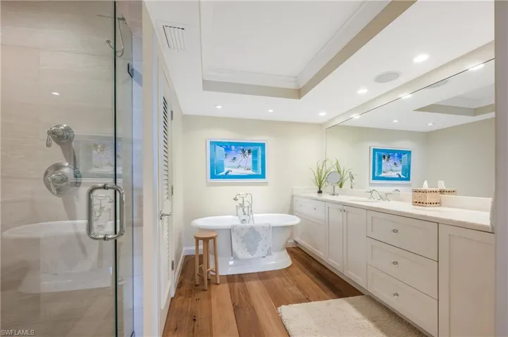 Separate shower and tub as well as a two sink vanity are wonderful features of this room.  Over head lighting and tray ceilings are attractive features.