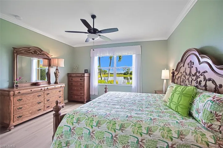 Bedroom with ceiling fan, ornamental molding, and light hardwood / wood-style flooring