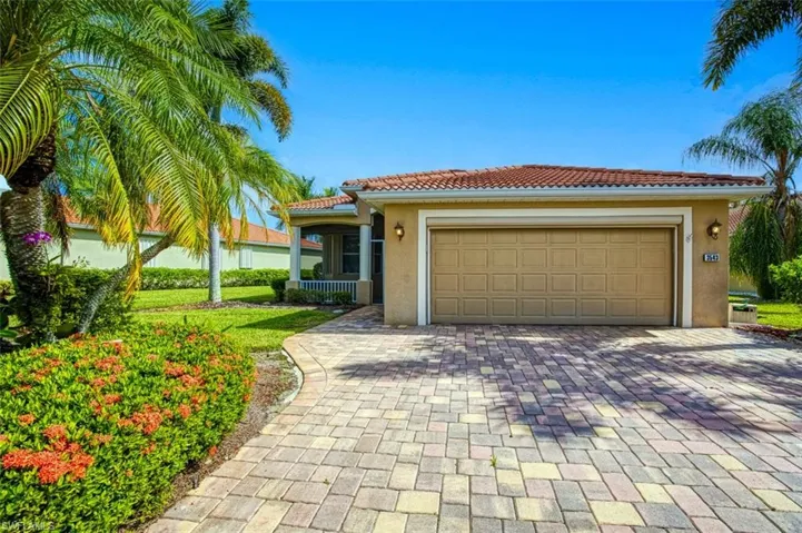 Mediterranean / spanish-style home featuring a garage and a front lawn