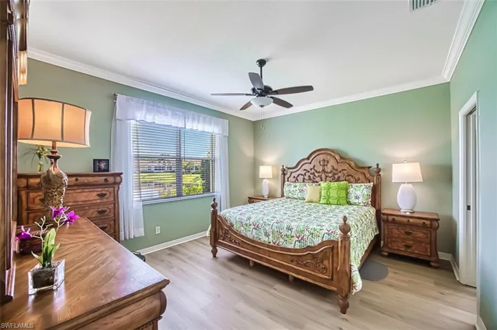Bedroom featuring ornamental molding, light hardwood / wood-style flooring, and ceiling fan