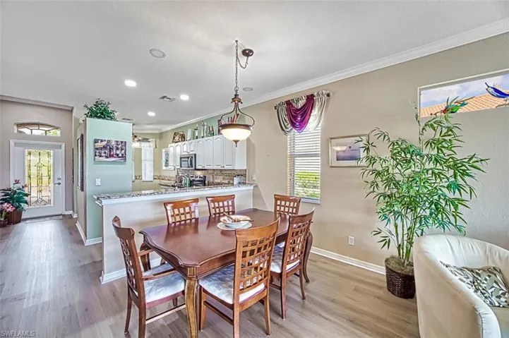 Dining area with crown molding and light hardwood / wood-style flooring