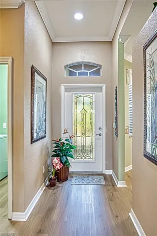 Entryway with crown molding and hardwood / wood-style flooring