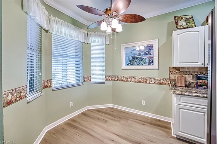 Unfurnished dining area featuring crown molding, ceiling fan, and light hardwood / wood-style floors