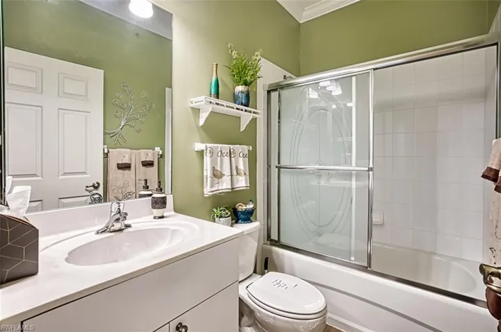 Full bathroom with toilet, combined bath / shower with glass door, and vanity
