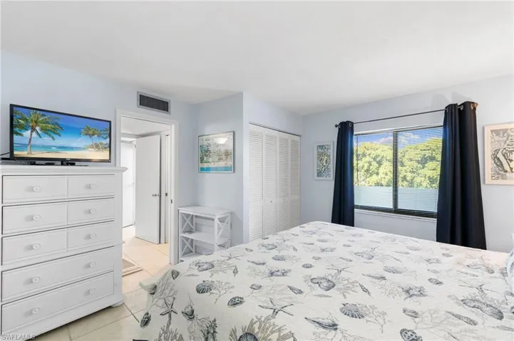 Bedroom with light tile patterned floors and a closet