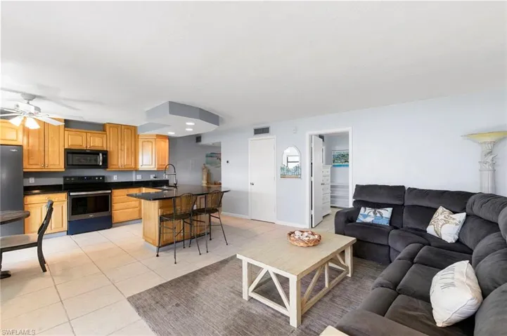 Living area featuring light tile patterned flooring, ceiling fan, and recessed lighting