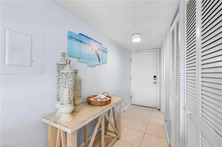 Doorway to outside featuring tile patterned floors and electric panel