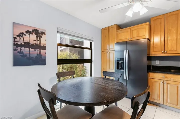 Dining space with light tile patterned flooring and a ceiling fan